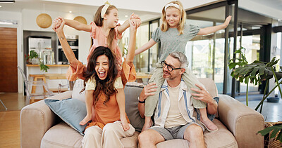 Buy stock photo Energy, playing and kids on shoulders of parents in living room of home for excitement or fun together. Daughter siblings, father and mother on sofa in apartment for bonding or games as happy family
