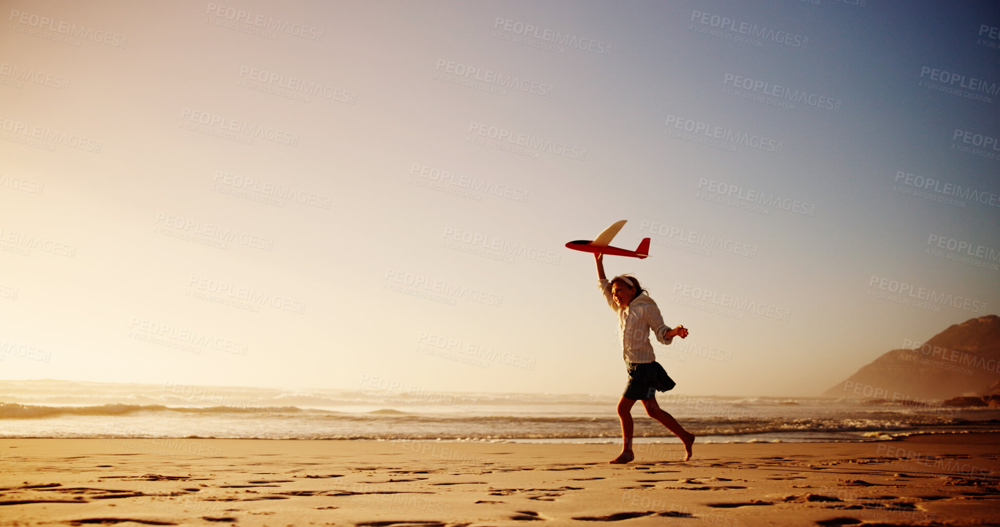 Buy stock photo Child, beach and playing with airplane toy for flying game, sunset fun or imagination travel on holiday. Mockup space, girl kid and running at ocean with fantasy flight, vacation freedom or adventure