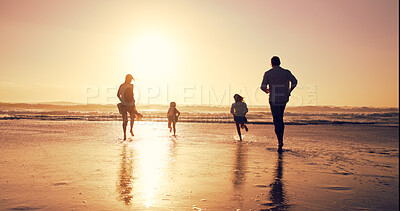 Buy stock photo Sunset, family and running in ocean water for holiday, bonding or energy with back outdoor. Race, mother and father with kids at beach with space, travel or play game with parents on summer adventure