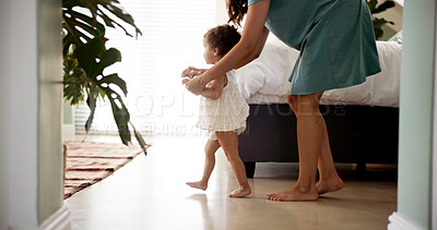 Buy stock photo Mother, child and learning to walk in home with holding hands, first steps or support with milestone. Happy family, baby and woman with teaching balance in bedroom with mobility or growth development