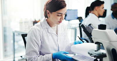 Buy stock photo Woman, scientist and check document in lab of medical study, experiment results and information. Person, microscope and paperwork for healthcare report, research and investigation feedback of vaccine