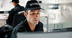 Security guard, watching and man with computer, surveillance or serious for safety in control room. Digital, online and person with tech for footage, private service or review of video for protection