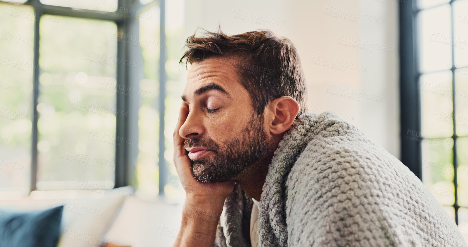 Buy stock photo Man, tired and sick with blanket on sofa, eyes closed or fever with fatigue, exhausted or headache in lounge. Person, burnout and rest on couch, sleep or migraine with flu in living room at apartment