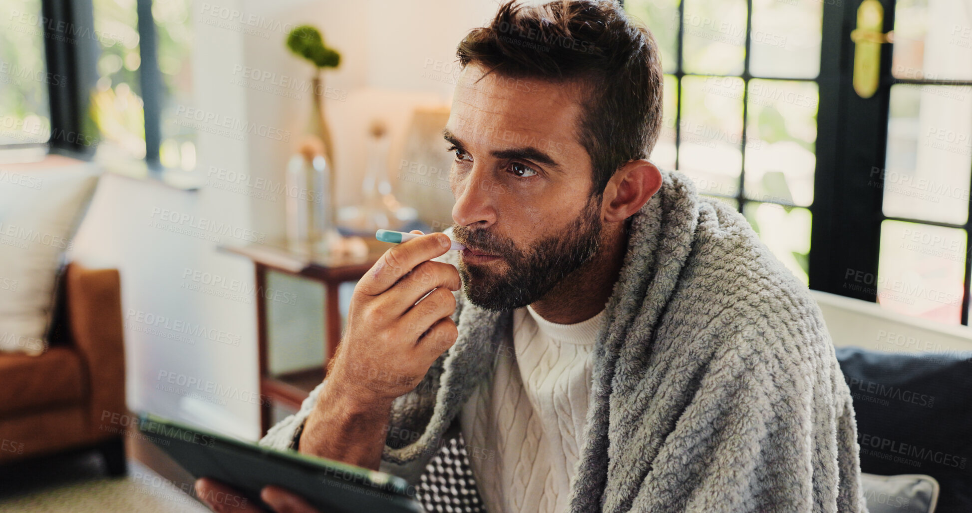Buy stock photo Tablet, man and sick with thermometer in home, check fever and influenza with research for symptoms. Sofa, male person and illness with temperature for flu, consultation and telehealth with digital