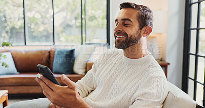 Buy stock photo Phone, relax and smile with man on sofa in living room of home for break, satisfaction or wellness. App, social media and time off with happy person in apartment for morning or weekend communication