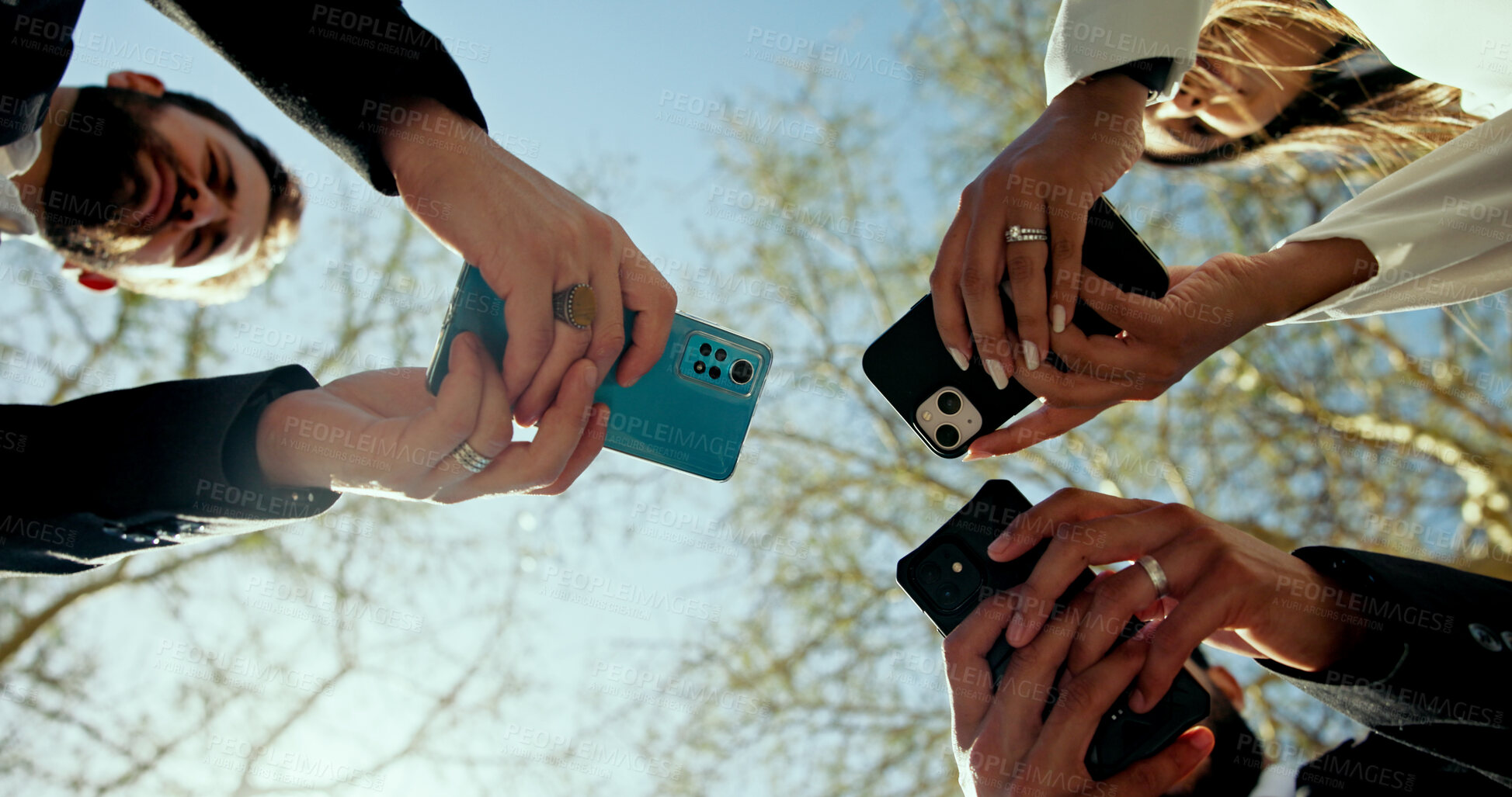 Buy stock photo Business people, hands and phone in circle outdoor for global connection, team chat and b2b networking. Low angle, employees and smartphone at park for data sharing, online news and corporate website