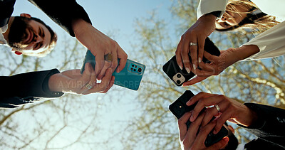 Buy stock photo Business people, hands and phone in circle outdoor for global connection, team chat and b2b networking. Low angle, employees and smartphone at park for data sharing, online news and corporate website