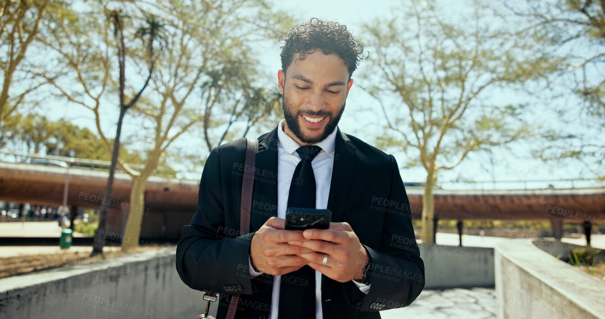 Buy stock photo Businessman, phone and happy in city, texting and park for notification, chat or outdoor on commute. Person, low angle and excited with contact for deal, networking or email on mobile app in Colombia
