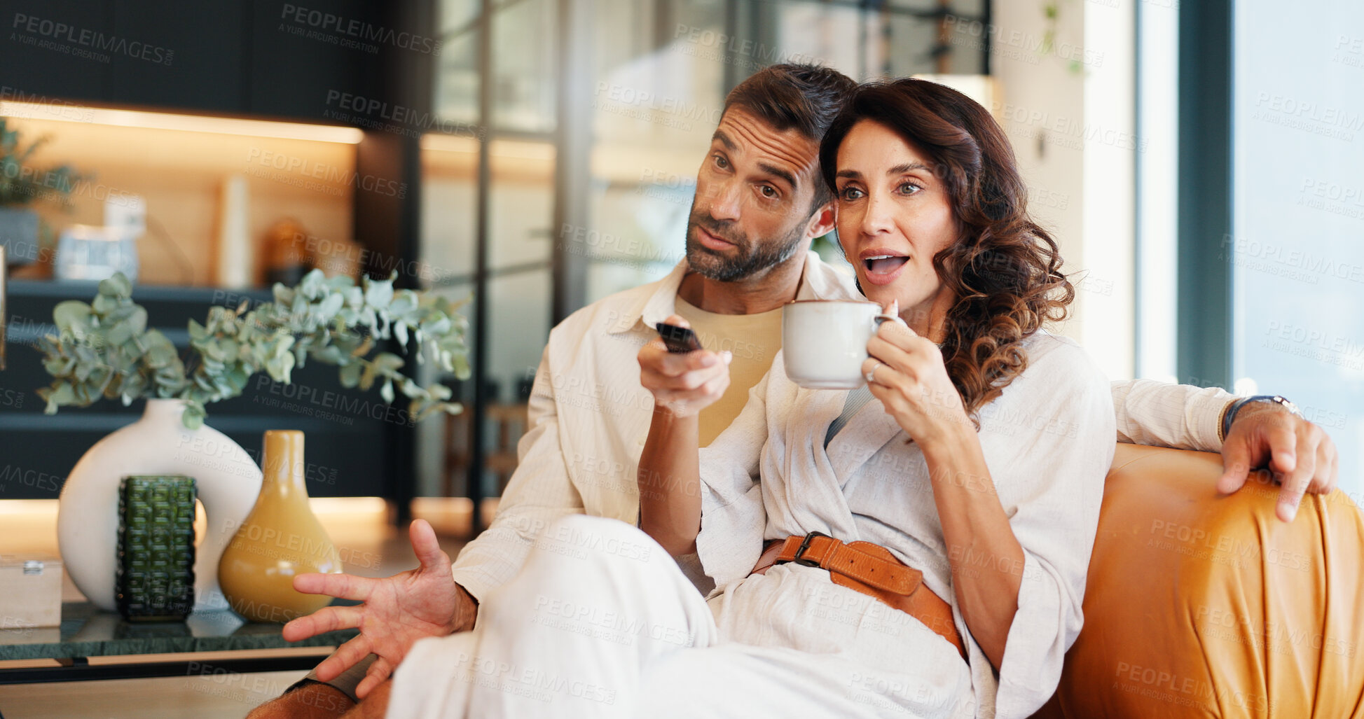 Buy stock photo Couple, watching tv and coffee on sofa, relax or excited with show, movie or streaming subscription in lounge. Mature people, woman and man with remote control, television or film on couch at house