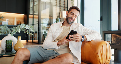 Buy stock photo Home, relax and man on sofa, smartphone and smile with message to contact, social media and connection. Person, apartment or guy on couch, cellphone and internet with funny meme or email notification