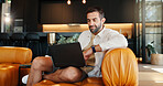 Laptop, remote work and sofa with man in home for research or small business development. Computer, reading and report with freelance entrepreneur in living room of apartment for startup planning