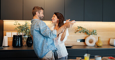 Buy stock photo Mature couple, smile and dancing in kitchen with love, bonding and celebration for anniversary in home. People, man and woman with holding hands, excited or playful rhythm for relationship at house