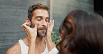 Skincare, couple and cream on face in home for skin hydration, morning routine or hyaluronic acid. Love, people or cosmetics product application for grooming, wellness support and bonding in bathroom