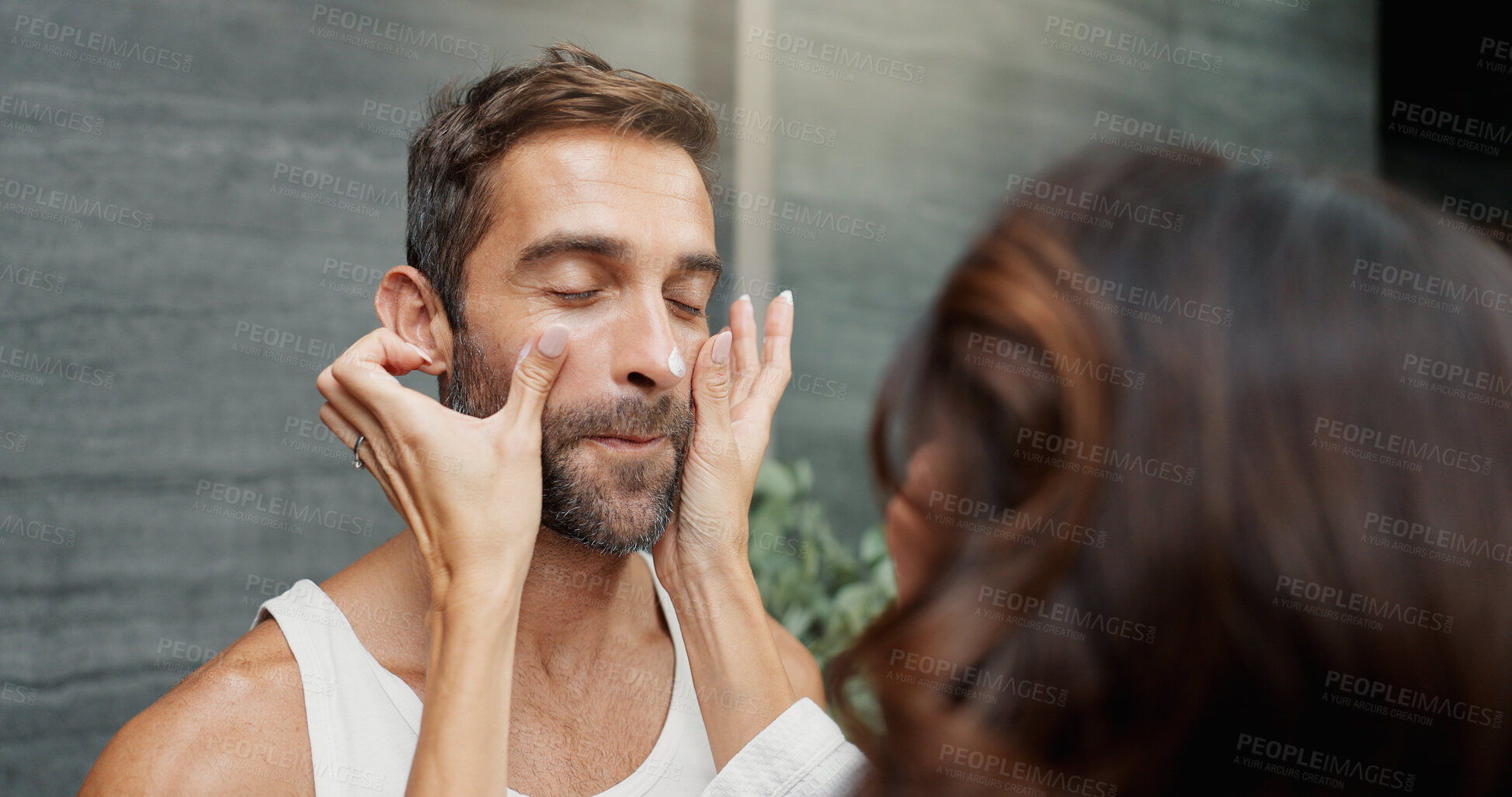 Buy stock photo Skincare, couple and cream on face in home for skin hydration, morning routine or hyaluronic acid. Love, people or cosmetics product application for grooming, wellness support and bonding in bathroom