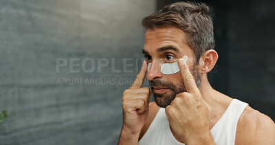 Buy stock photo Beauty, eye mask and product with man in bathroom of home for antiaging cosmetics or wellness. Application, dermatology and facial treatment with person in apartment for morning skincare routine