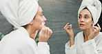 Skincare, mirror and woman with face cream in bathroom for skin hydration, collagen treatment and morning routine. Beauty, reflection and product application for moisturizer, wellness and anti aging