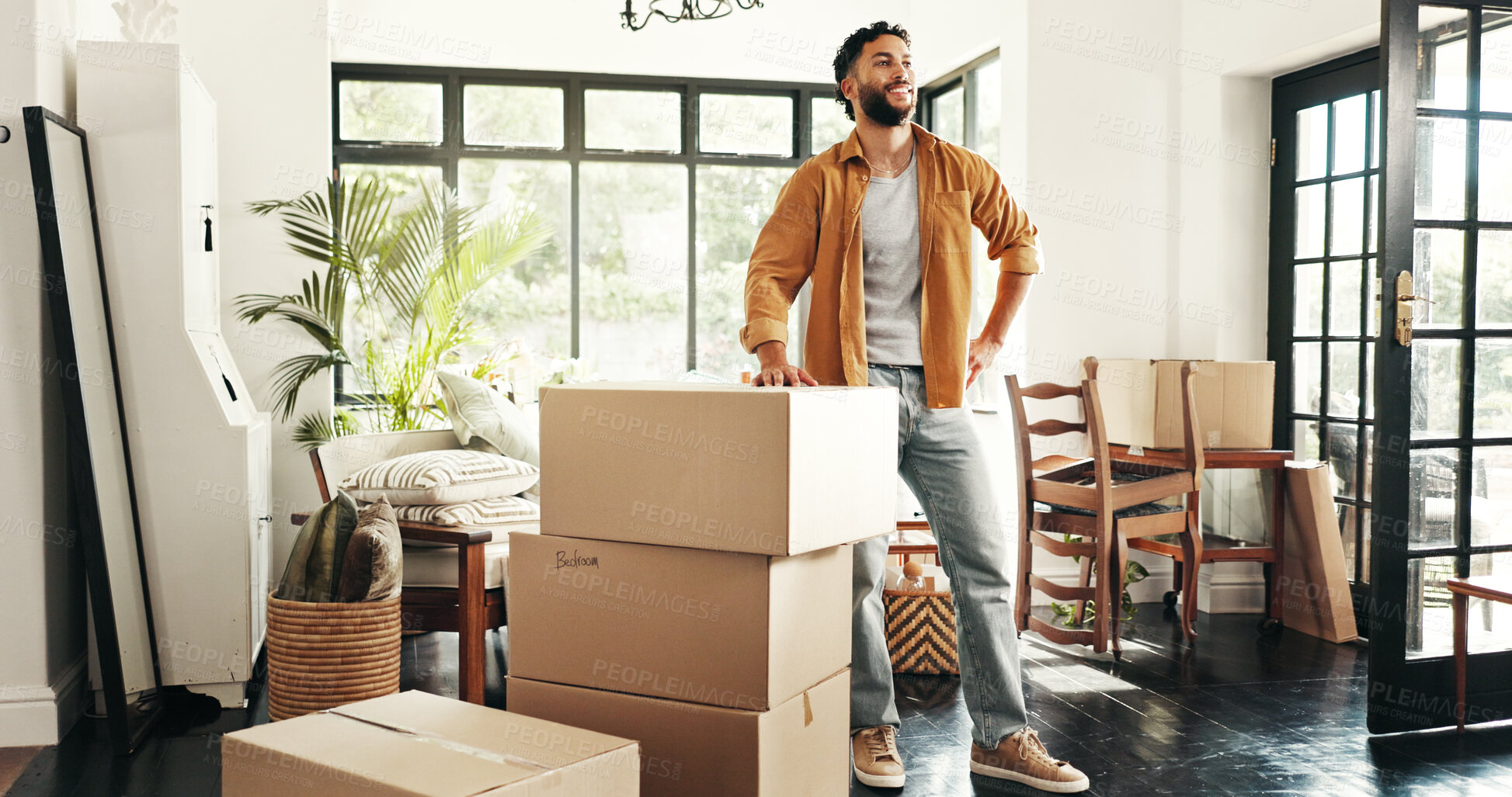 Buy stock photo Moving in, smile and man with boxes, thinking and ownership of property with mortgage or real estate. Relocation, buyer and person with cardboard in living room, investment or purchase with home loan