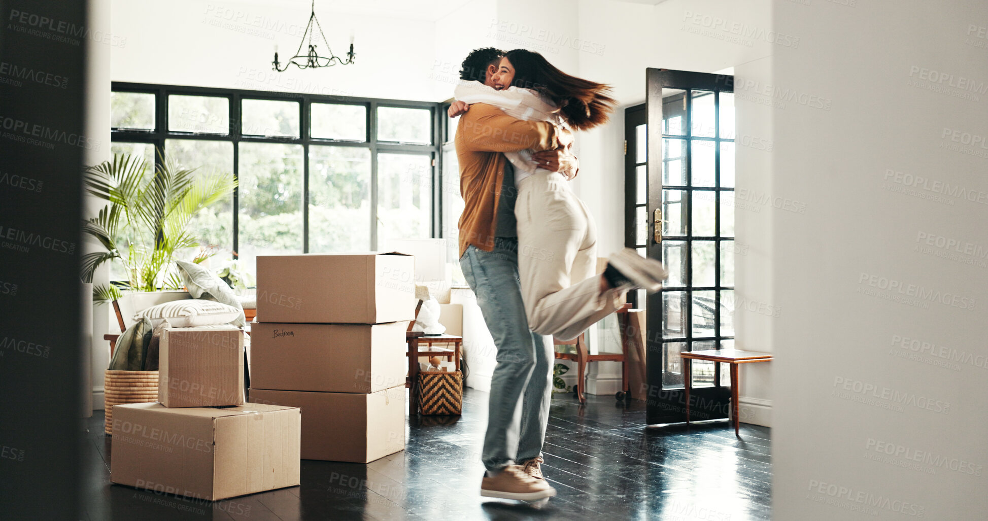 Buy stock photo Celebration, hug and couple in new house, real estate and ownership of property with mortgage or lounge. Relocation, happy and people with boxes in living room, investment and purchase with home loan