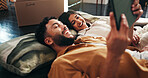 Happy, couple and relax on tablet in new home for social media, interior design and online shopping. People, digital and search of planning, furniture choice and boxes for start of renovation process