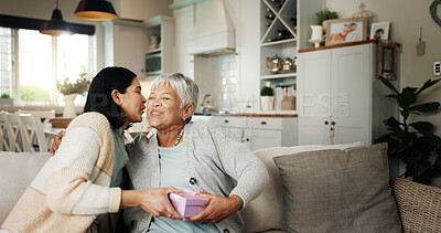 Buy stock photo Birthday, gift or kiss with senior mother on sofa in living room of home together for bonding or celebration. Box, love or present with parent and woman daughter in apartment for event or milestone