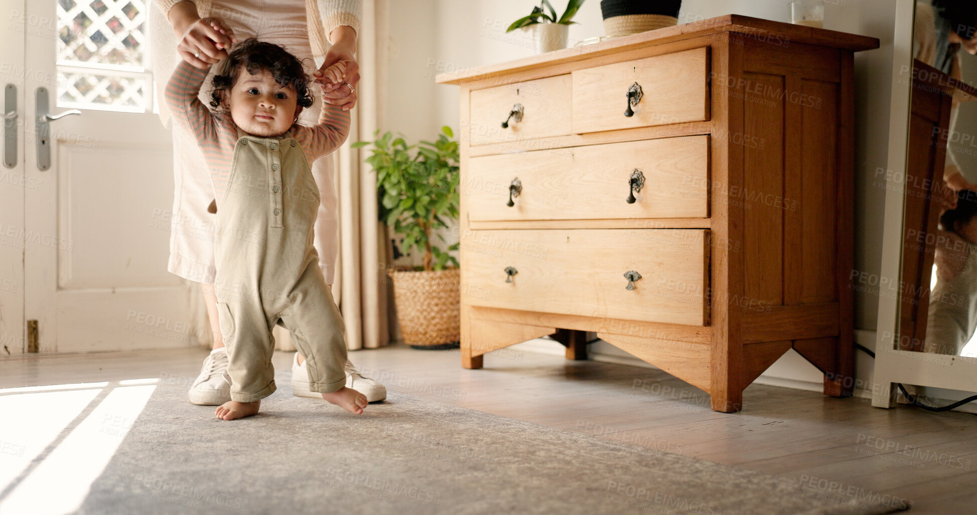 Buy stock photo Parent, baby and holding hands for first steps in home with mobility support, balance and child development. Milestone, person and teaching toddler to walk, learning coordination or growth in lounge