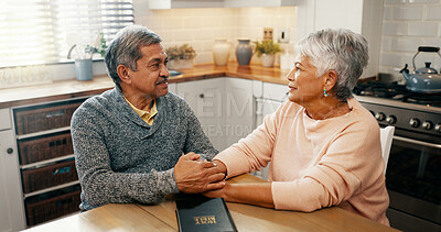 Buy stock photo Senior couple, bible study and talk with religion in home, holding hands and faith with worship in retirement. Elderly man, woman and support for peace, book and praise God with gratitude in house