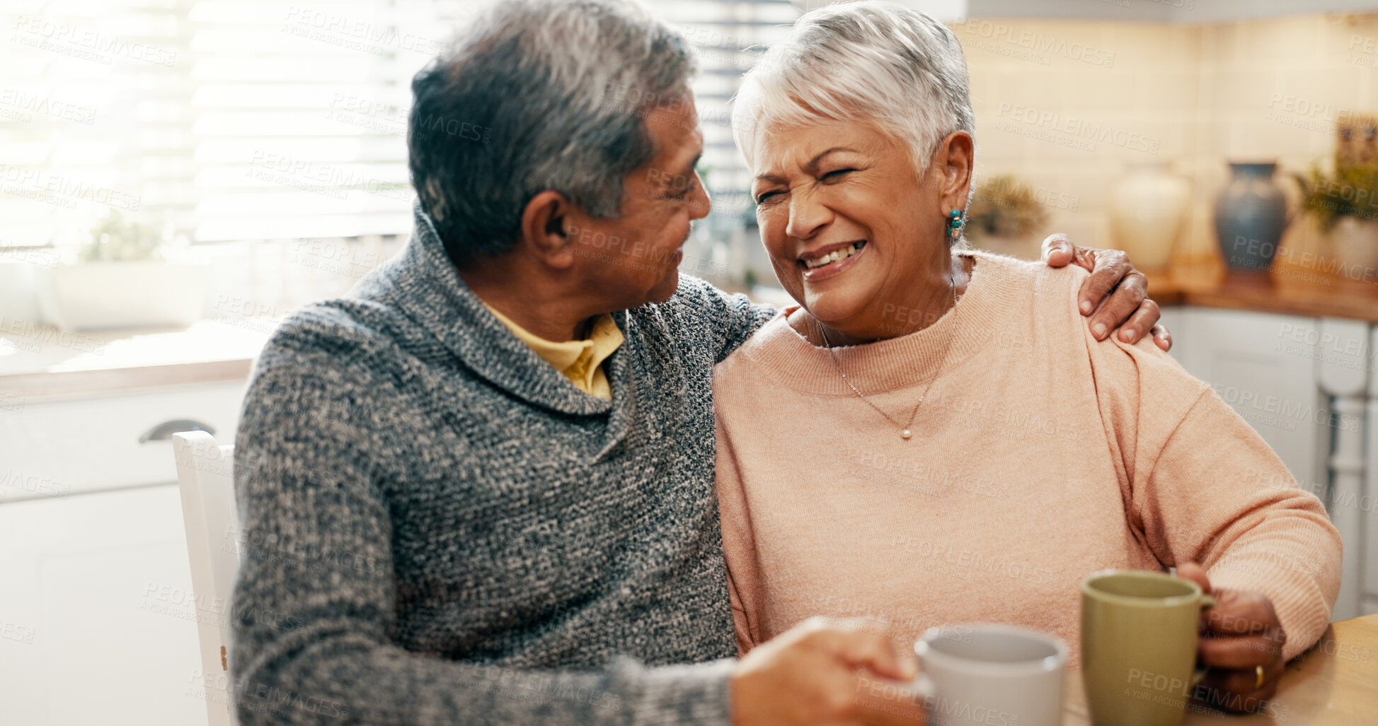 Buy stock photo Hug, laughing and senior couple with coffee, home and bonding with beverage in kitchen, people and morning. Happy, old man and mature woman with tea in house, comfortable and conversation for family