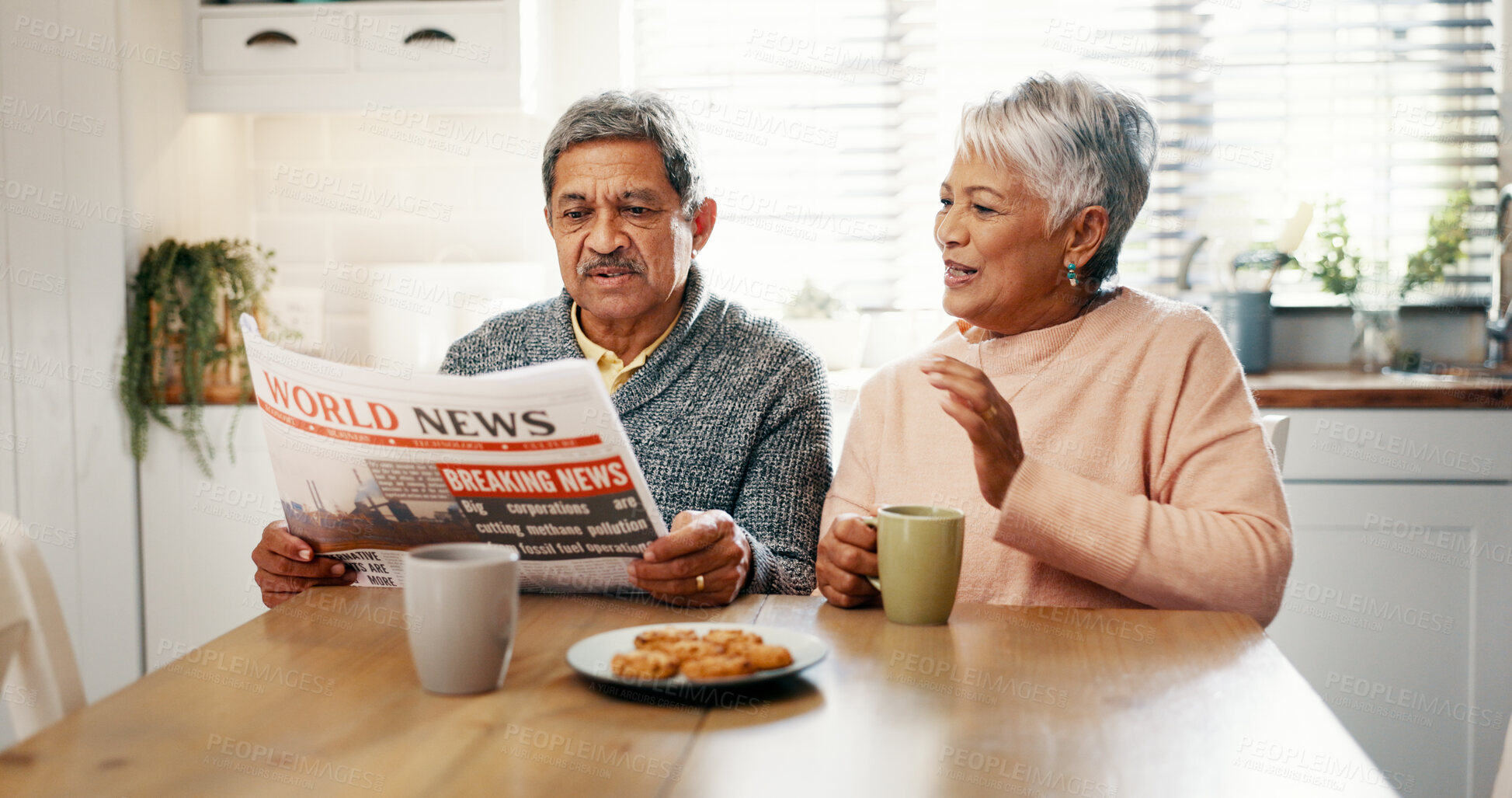 Buy stock photo Senior couple, newspaper and coffee in kitchen, discussion and breakfast with headline, update and story. Elderly man, woman and talk with tea cup, article or newsletter with bonding in retirement