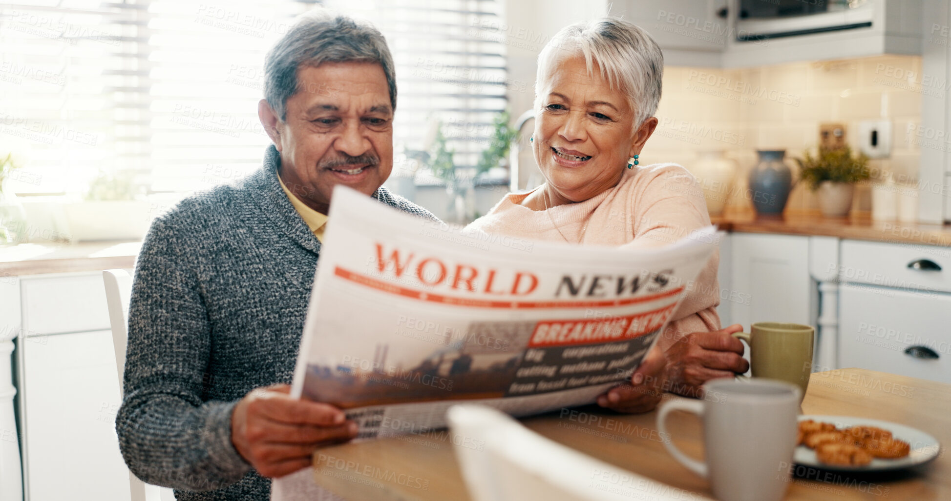 Buy stock photo Senior couple, newspaper and morning in kitchen, talking and coffee with headline, update and story. Elderly man, woman and smile with tea cup, article and reading newsletter with bonding in house