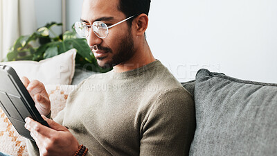 Buy stock photo Tablet, research and man on sofa in home reading online blog, post or news article for politics. Digital technology, glasses and male person with social networking in living room at apartment.