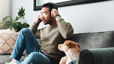 Buy stock photo Man, relax and headphones with dog on sofa for listening to music, podcast audio and animal affection. Person, glasses or puppy for streaming radio, playlist sound and bonding with loyal pet at house