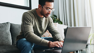 Buy stock photo Typing, online and laptop with man on sofa for freelancer, networking and email response. Reading, communication and remote worker with person in living room of home for business proposal or research