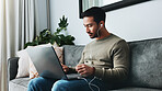Home, earphones and man with laptop on sofa for watching videos for online course, lesson and tutorial. Remote work, living room and person on computer listening to podcast, audio and recording