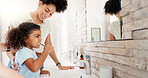 Girl, mom and child brushing teeth for learning, morning routine or teaching healthy oral habits in home. Happy parent, kid and cleaning for dental care in bathroom with toothbrush, mother or hygiene