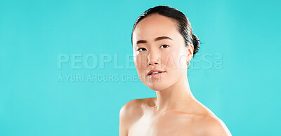 Buy stock photo Portrait, skincare and Asian woman with cosmetics, shine and beauty on blue studio background. Japanese person, aesthetic and model with healthy skin, dermatology and grooming with mockup space