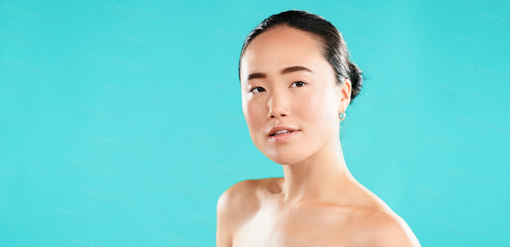 Buy stock photo Portrait, skincare and Asian woman with cosmetics, shine and beauty on blue studio background. Japanese person, aesthetic and model with healthy skin, dermatology and grooming with mockup space