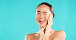 Wink, skincare and portrait of Asian woman in studio for wellness, cosmetics and facial treatment. Dermatology, mockup space and person with emoji for health, salon and beauty on blue background
