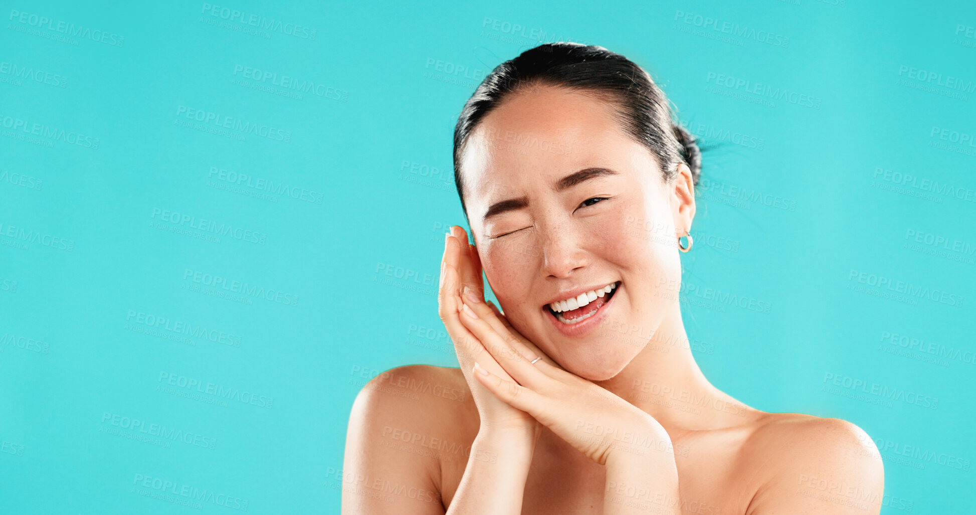 Buy stock photo Beauty, wink and portrait of Asian woman in studio for wellness, cosmetics or facial treatment. Dermatology, mockup space and person with emoji for health, skincare or spa benefits on blue background