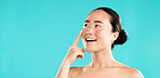 Thinking, skincare and Asian woman in studio for beauty, wellness and facial treatment choice. Dermatology, mockup space and person with gesture for health, cosmetics and decision on blue background