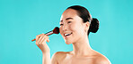 Studio, asian woman and smile with brush for makeup, foundation and application of cosmetics. Mockup space, female person and happy model with tool for powder, beauty and wellness by blue background