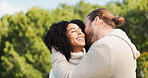 Love, laugh and kiss with interracial couple in park for relax, date and romance. Happiness, embrace and marriage with man and woman hug in nature for commitment, loyalty and bonding together