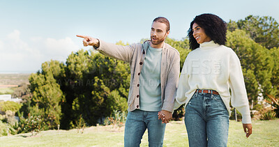 Buy stock photo Love, holding hands and pointing with interracial couple in park for relax, date and romance. Happiness, walking and marriage with man and woman in nature for commitment, loyalty and bonding