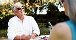 Happy, senior man and laugh on date with romance, funny joke and partner love for retirement brunch. Smile, elderly couple and talking with champagne, anniversary celebration and commitment of picnic
