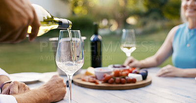 Buy stock photo Hand, pouring wine and couple on date with romance, anniversary celebration and breakfast picnic. Elderly people, champagne and charcuterie board, bonding and marriage commitment in backyard at house