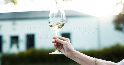 Buy stock photo Hand, glass and person outdoor with white wine, luxury drink and closeup on farm or countryside on holiday. Winery, tourist and tasting alcohol at vineyard or swirl beverage on vacation in nature
