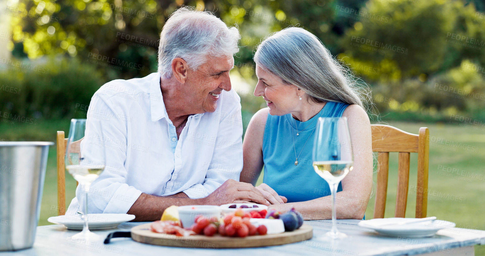 Buy stock photo Date, backyard and old couple with love, food and bonding together with celebration. Retirement, senior man or mature woman with champagne, outdoor or romance with relationship, marriage or smile