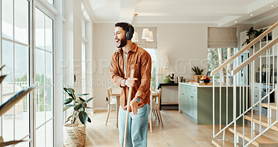 Buy stock photo Broom, music and sing with man in home for chores, responsibility or spring cleaning. Dance, headphones and sweeping with happy person in apartment for housekeeping, listening or radio streaming