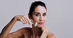 Beauty, derma roller and portrait of woman in studio for antiaging cosmetics or dermatology. Gua sha, massage and skincare with person isolated on gray background for crystal stone face treatment