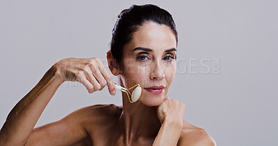 Buy stock photo Beauty, roller and portrait of woman in studio for antiaging cosmetics or dermatology. Gua sha, massage and skincare with person isolated on gray background for crystal stone facial treatment