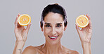 Portrait, orange and woman with skincare, wellness and dermatology on gray studio background. Mature person, organic cosmetics or model with confidence, citrus and natural detox with beauty or facial